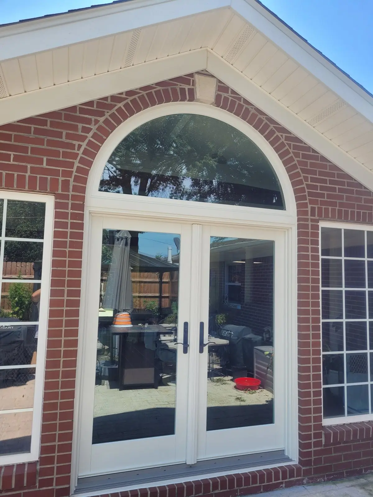 Brick entry with an arched-top window and new door