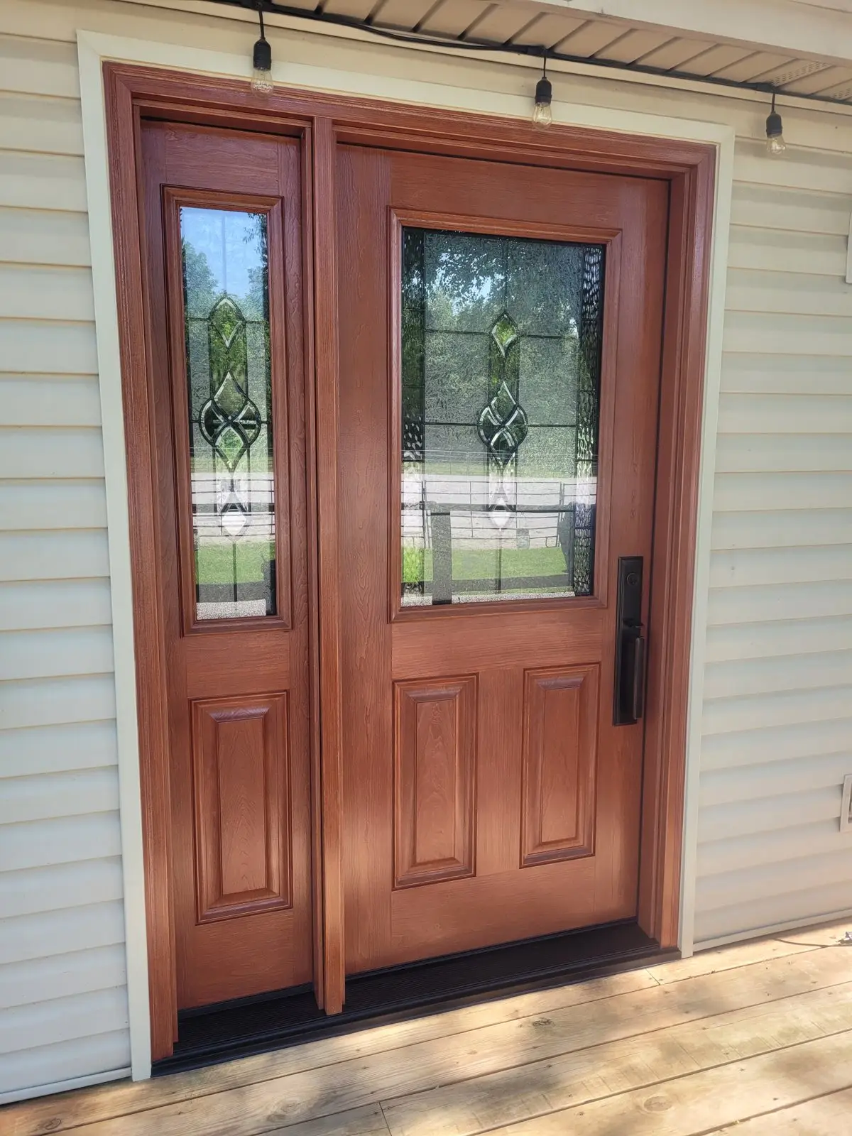 New wood entry door with glass on a sided home