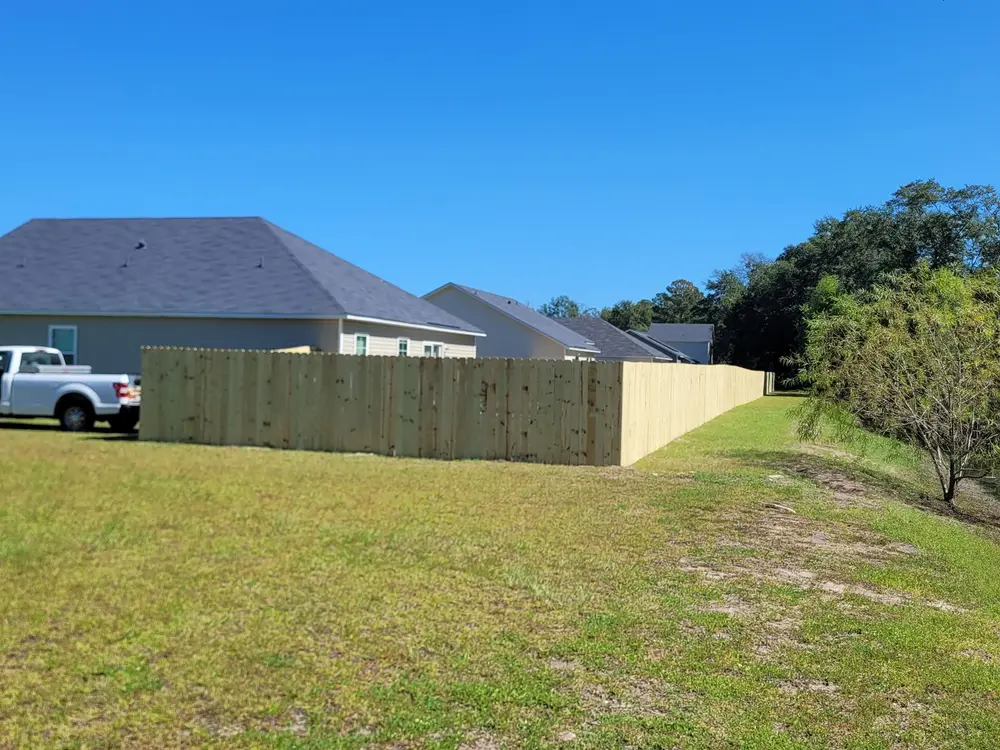 Finished wood privacy fence along a back yard