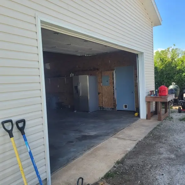 Garage exterior with finished siding and trimmed opening
