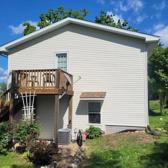 The same home finished with new siding, deck intact, trimmed and squared away