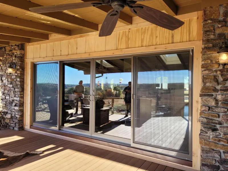 Sunroom with new sliding glass doors and a stone accent wall